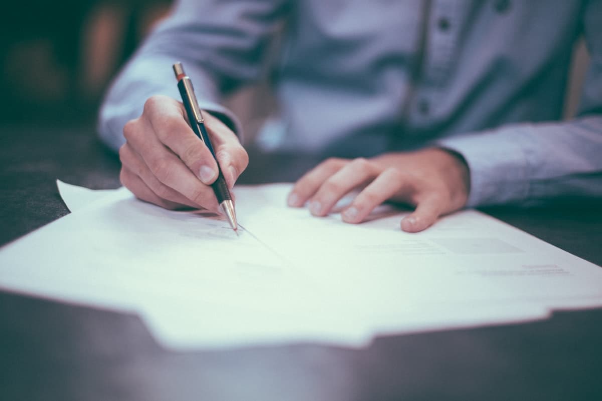 Person working at a desk with laptop and paperwork for government contractor registration